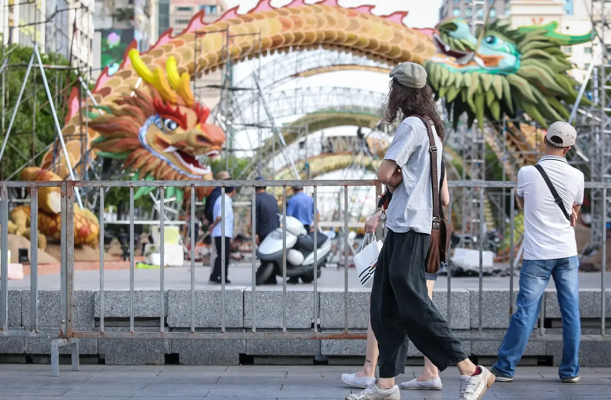 Tourist watching the dragon figure on Nguyen Hue Flower Street