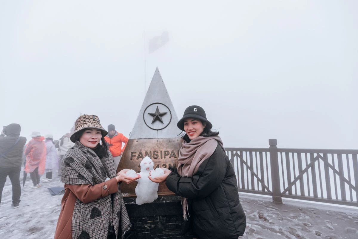 Tourists check-in snowy Fansipan Mountain in Sapa