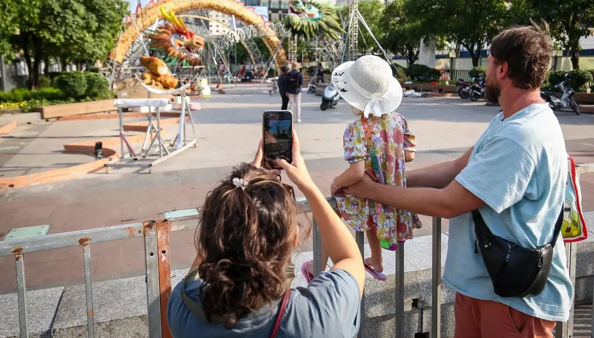 Tourists talking photos of the dragon figure on Nguyen Hue Flower Street