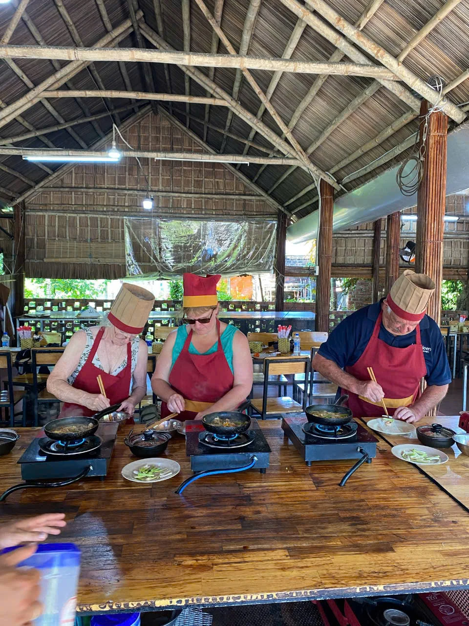 Participants preparing ingredients beside portable stoves during a hands-on cooking class.