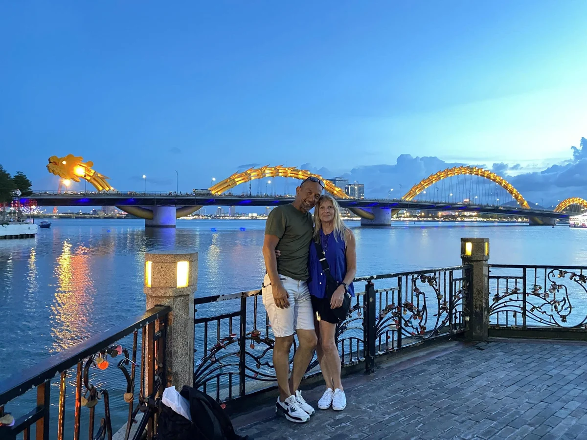 Tour guests beside the illuminated Dragon Bridge in Da Nang