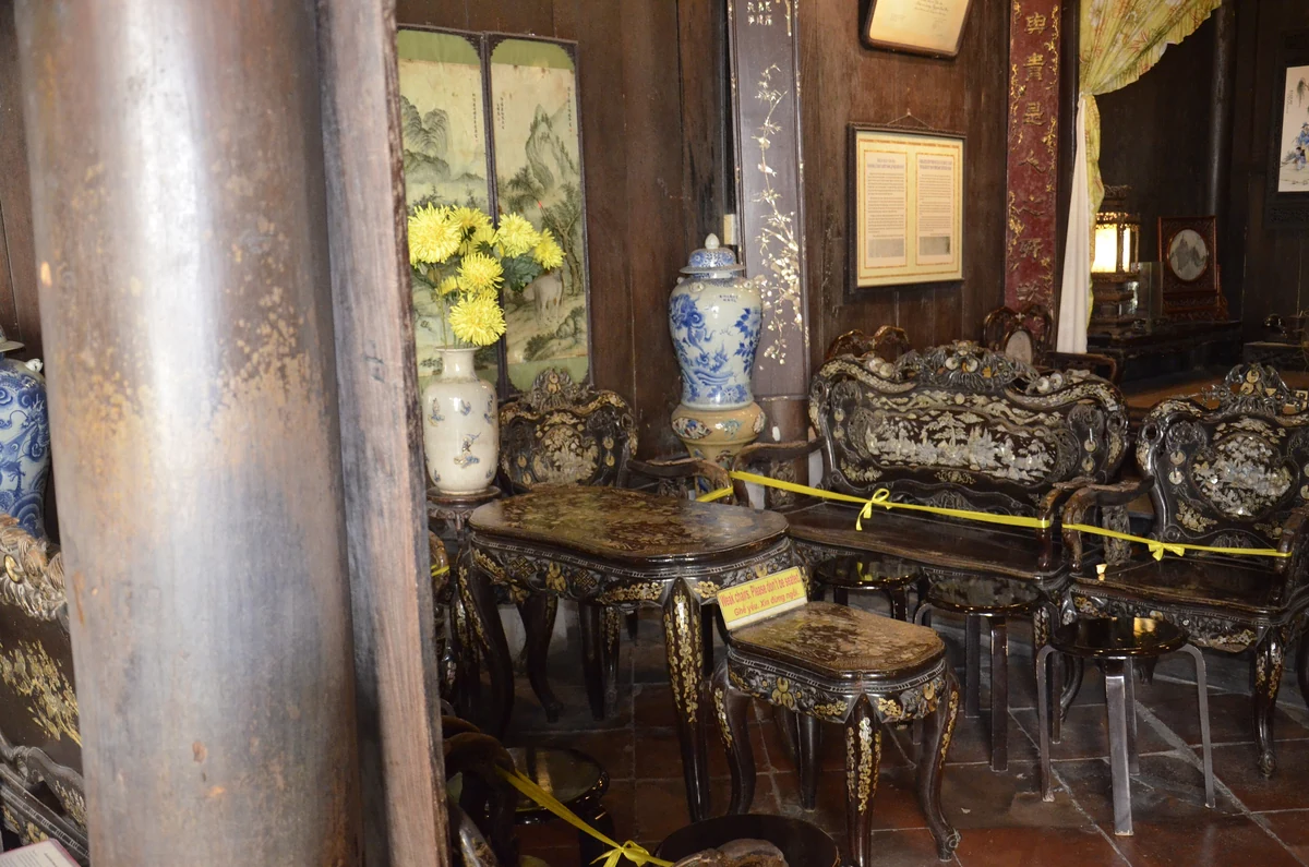 Carved timber panels, mother-of-pearl furniture and ceramic vases inside Tan Ky Ancient House in Hoi An.