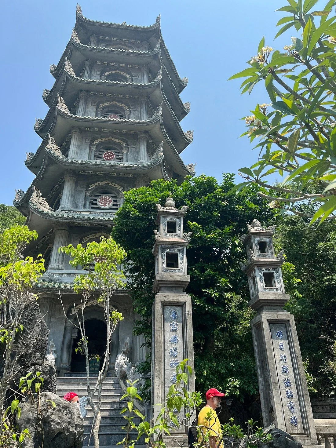 Xa Loi Tower and stone gate pillars surrounded by trees on Thuy Son in the Marble Mountains.